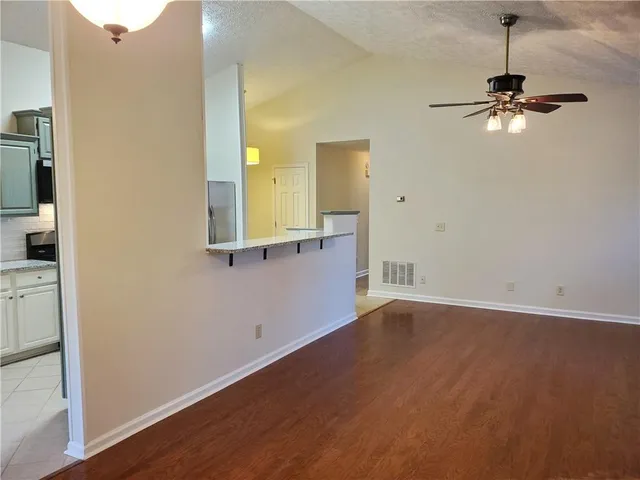a view of a room with a hardwood and a ceiling fan