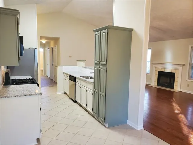 a kitchen with stainless steel appliances granite countertop a refrigerator and a stove