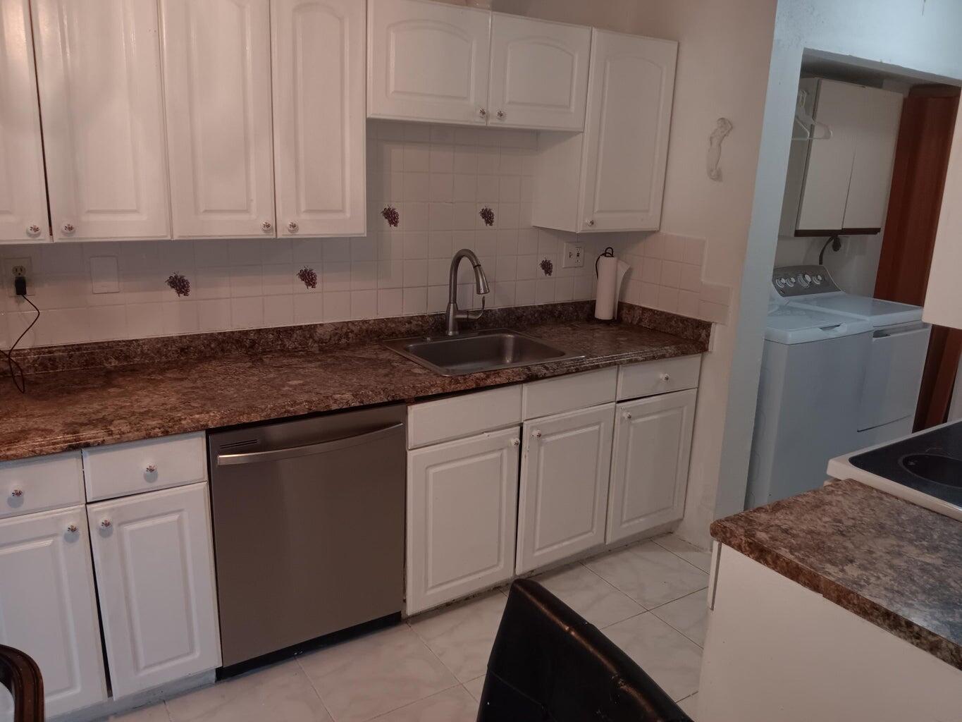 3450 Blue Lake Drive, Unit 204 Pompano Beach, FL 33064 - Photo 7 of 18 a kitchen with granite countertop white cabinets and sink