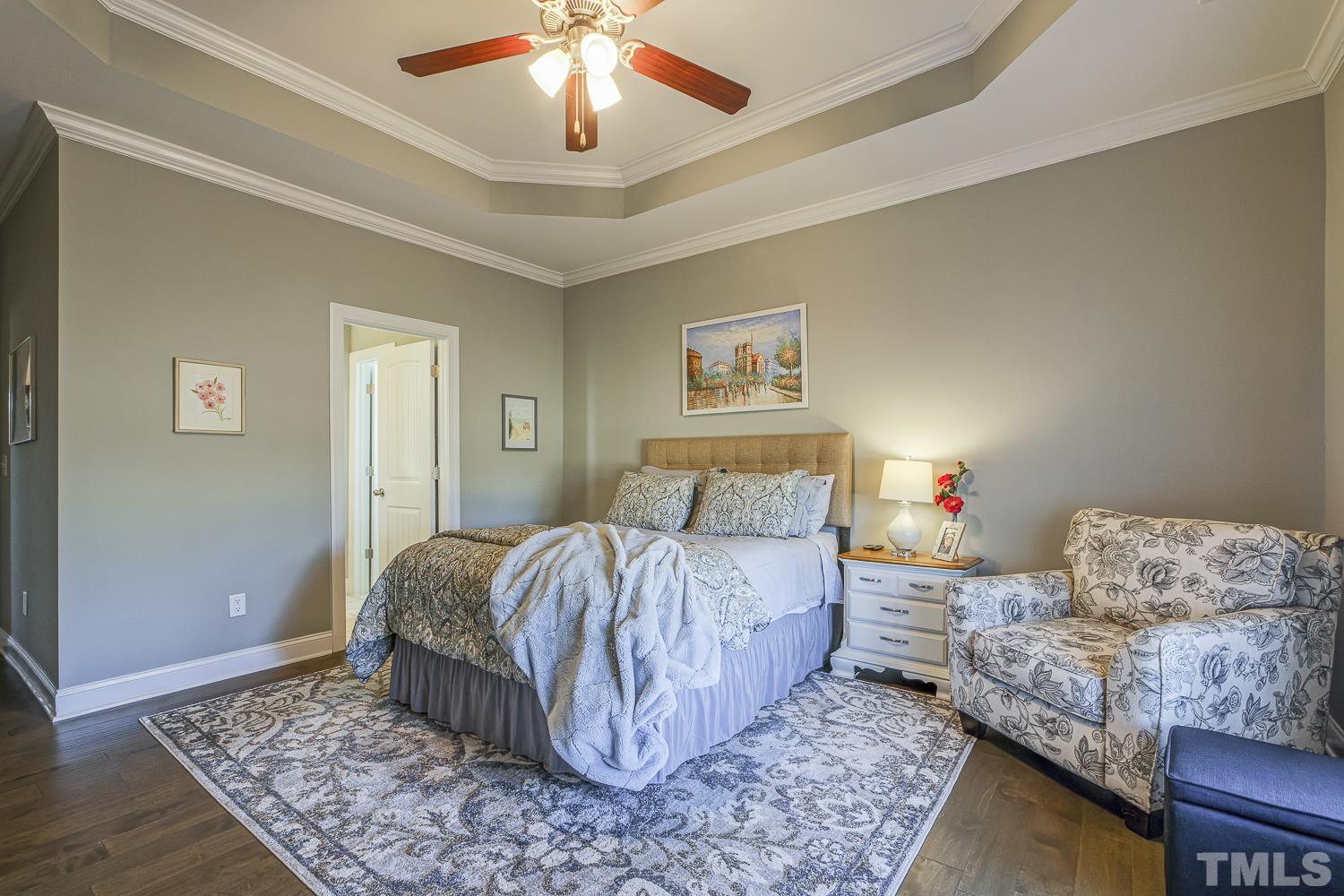 5516 Red Line Court Raleigh, NC 27603 - Photo 18 of 39 a bedroom with a bed and a chandelier