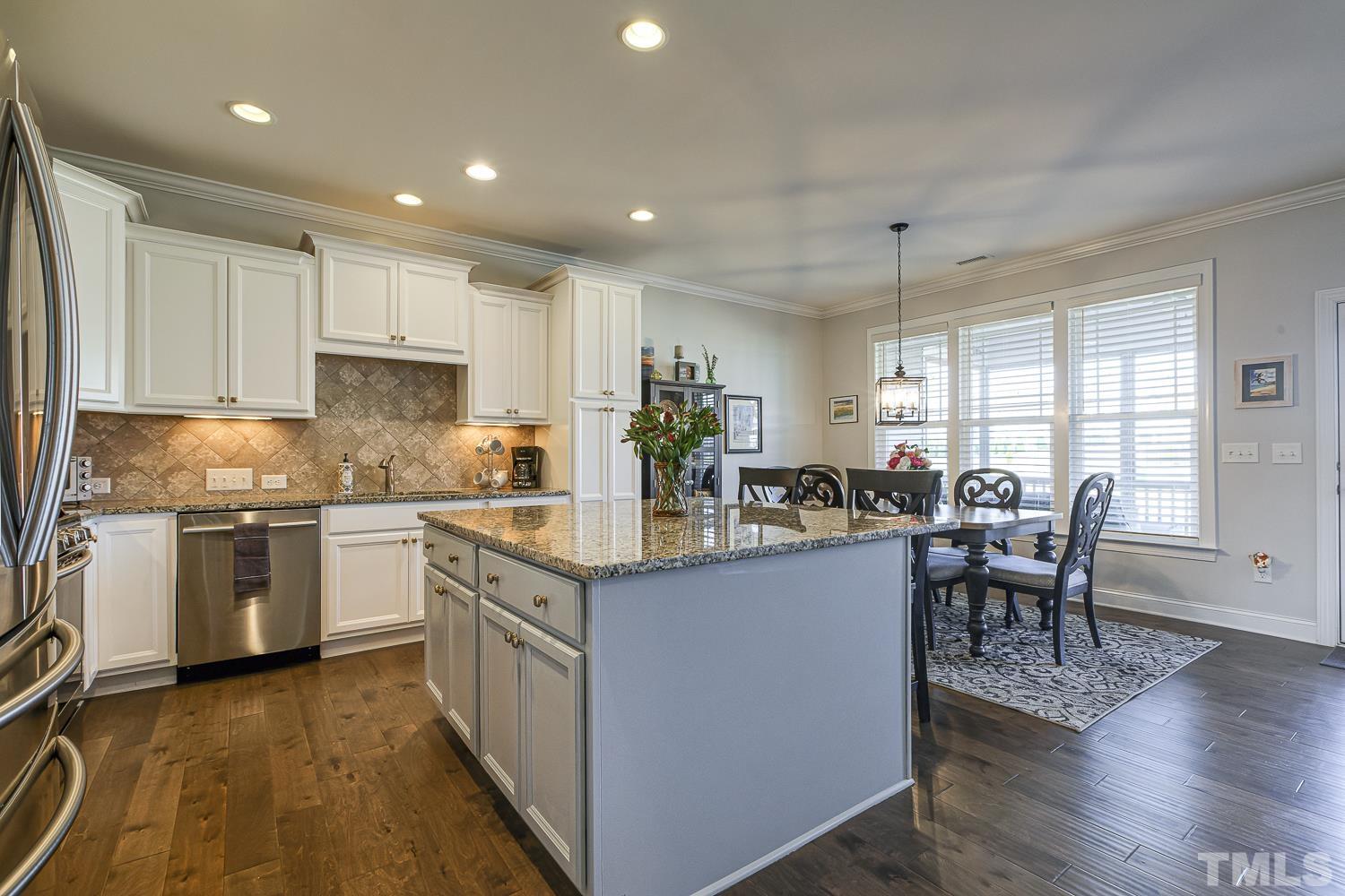 5516 Red Line Court Raleigh, NC 27603 - Photo 4 of 39 a kitchen with a table chairs microwave and cabinets