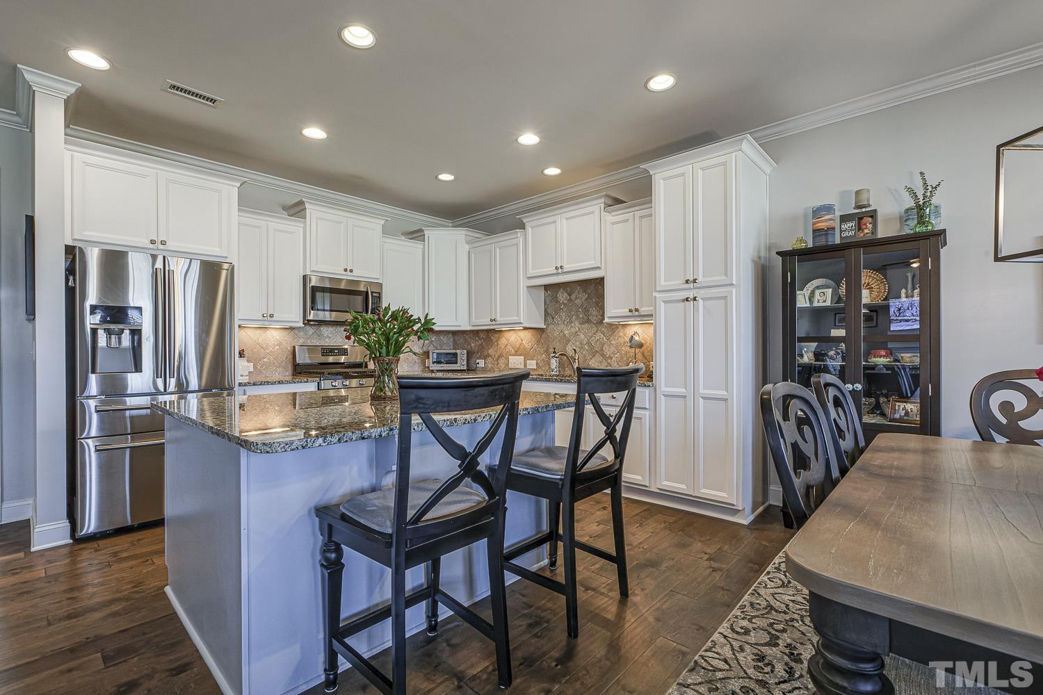 5516 Red Line Court Raleigh, NC 27603 - Photo 6 of 39 a kitchen with stainless steel appliances kitchen island granite countertop a table chairs refrigerator and microwave