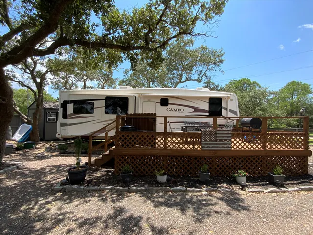 a front view of a house with a yard covered with trees