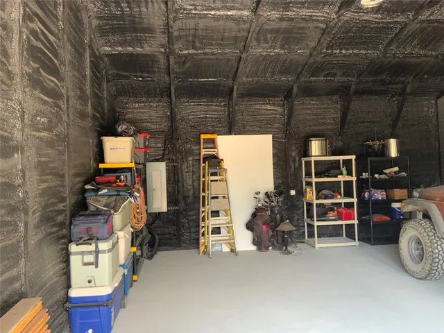 a view of a patio with table and chairs with wooden fence and large trees