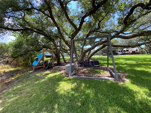 a front view of a house with a yard and trees