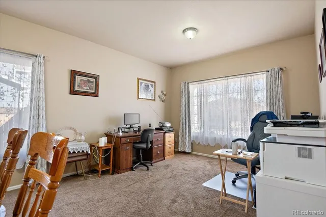 a living room with furniture a flat screen tv and kitchen view