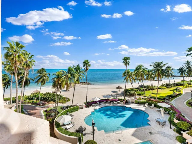 a view of a patio with table and chairs potted plants and large trees