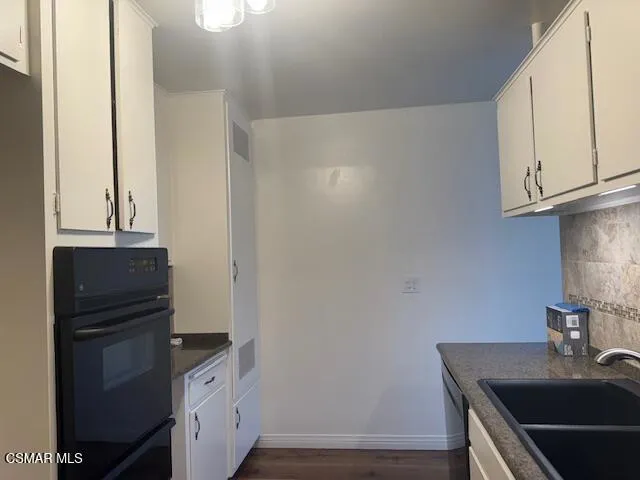 a kitchen with cabinets and a wooden floor