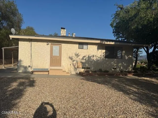 a view of a grey house with a yard