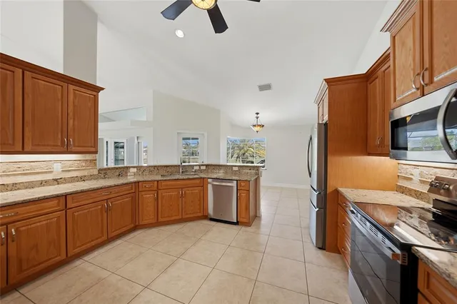 a kitchen with stainless steel appliances granite countertop a sink a stove and a refrigerator