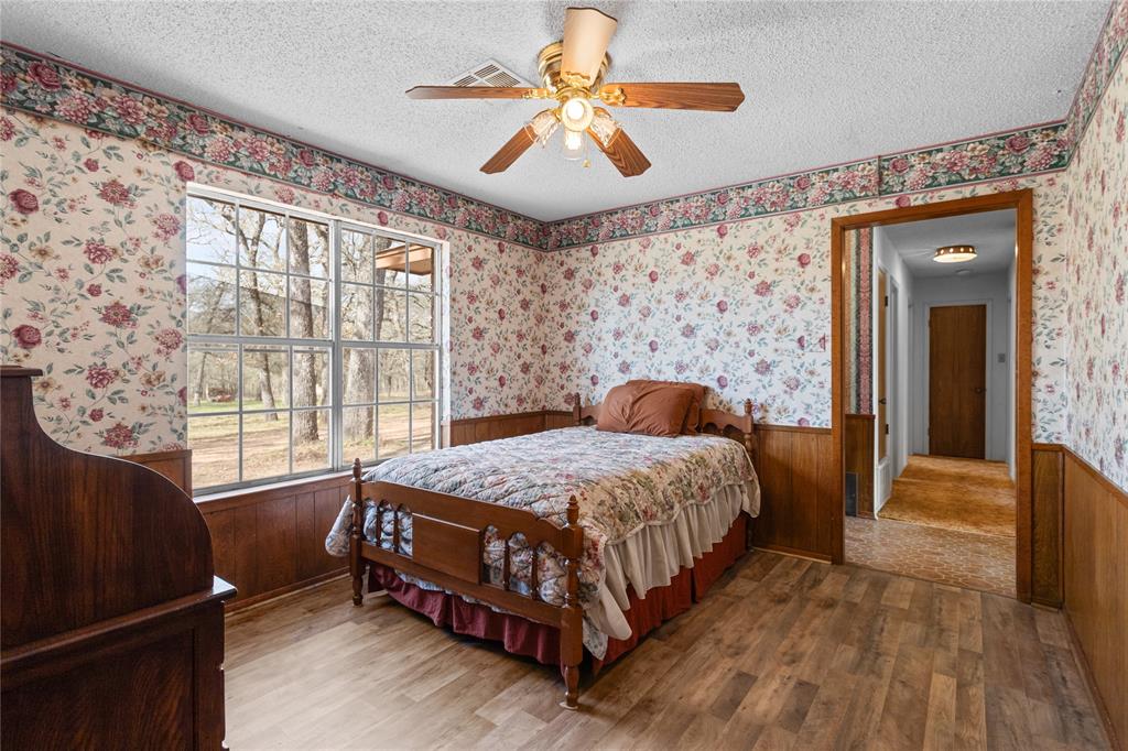1447 Red Gate Road Mart, TX 76664 - Photo 27 of 38 a bedroom with a bed and a chandelier