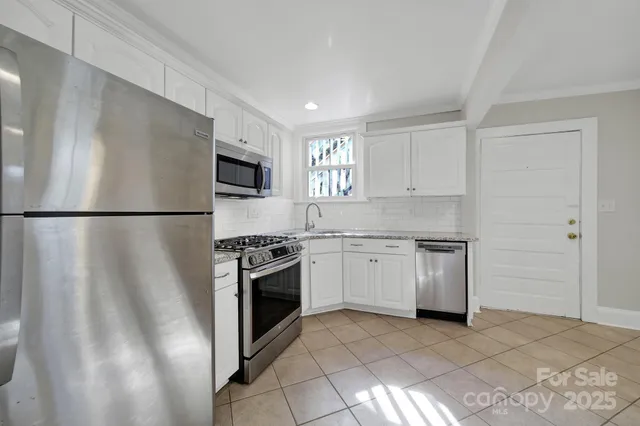 a kitchen with cabinets stainless steel appliances and a counter space