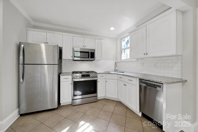 a kitchen with cabinets stainless steel appliances and a counter space
