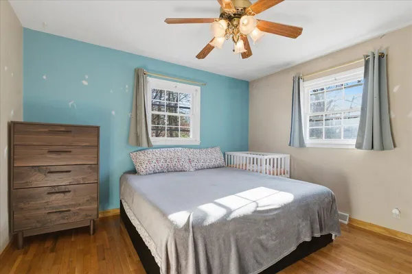 a bedroom with a bed and wooden floor