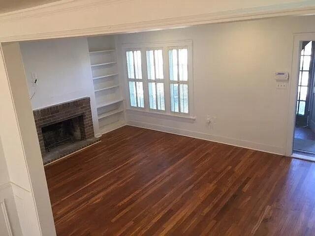 2915 21st Street Lubbock, TX 79410 - Photo 14 of 18 an empty room with wooden floor fireplace and windows