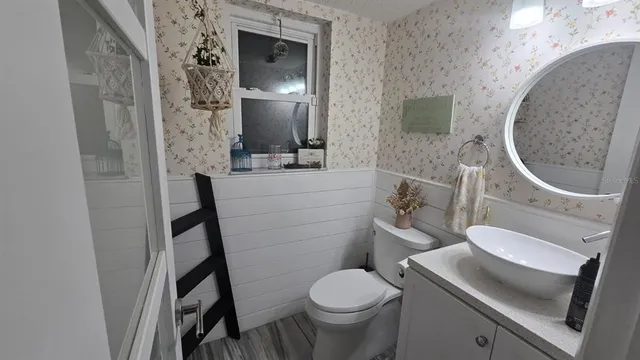 a bathroom with a toilet sink and mirror