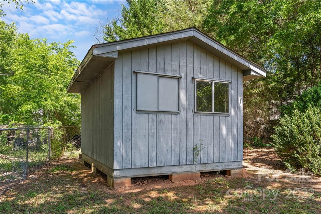 312 Brookside Drive Fort Mill, SC 29715 - Photo 23 of 23 a wooden house with a small yard plants and large trees