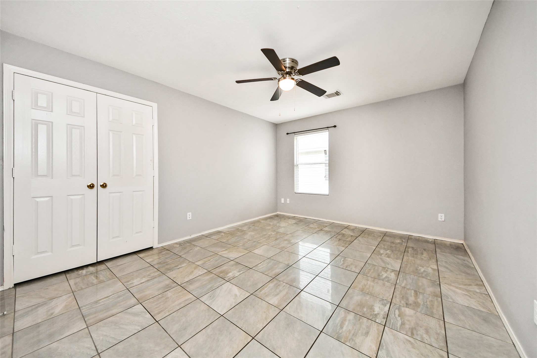 24019 Kingbriar Drive Spring, TX 77373 - Photo 24 of 41 Another spacious secondary bedroom offers a large double-door closet and a bright window, perfect for creating a cozy and comfortable personal space.
