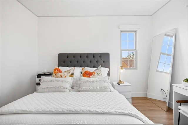 a bedroom with a bed and a white wall painting
