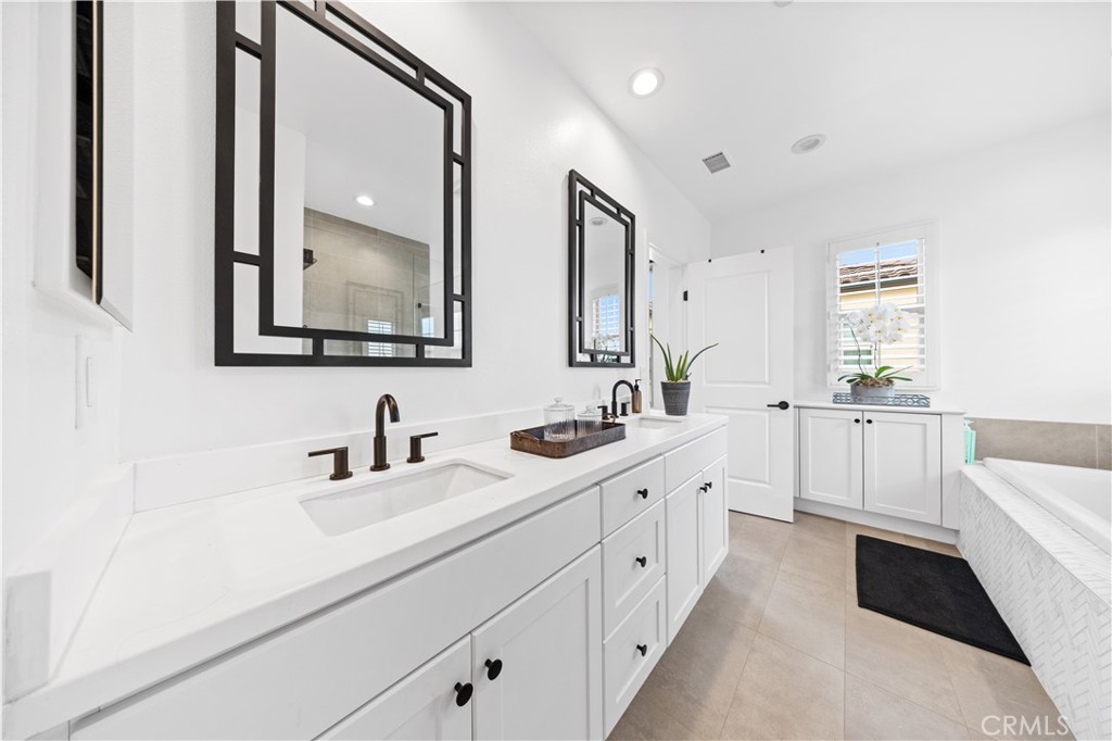 89 Kestrel Irvine, CA 92618 - Photo 26 of 36 a large white bathroom with a double vanity sink a mirror and a