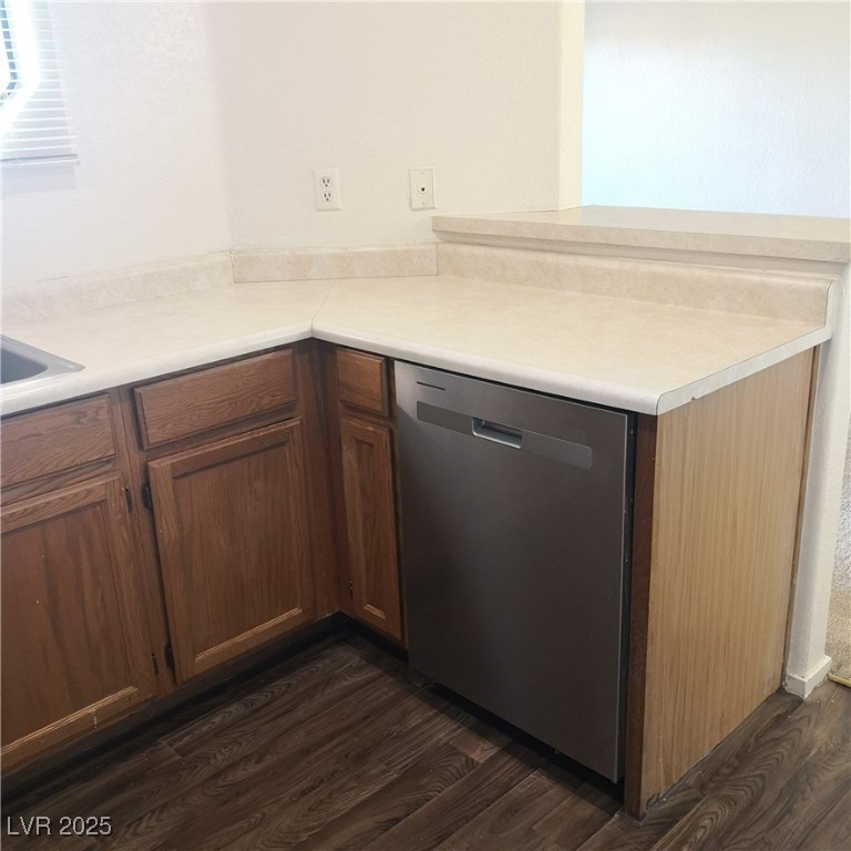 5026 South Rainbow Boulevard, Unit 203 Las Vegas, NV 89118 - Photo 11 of 31 Kitchen with stainless steel dishwasher, light countertops, dark wood finished floors, and brown cabinetry