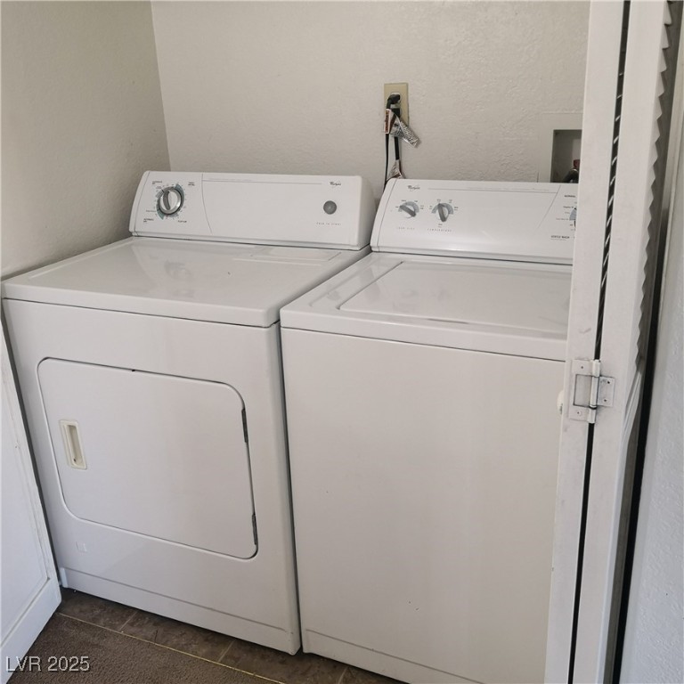 5026 South Rainbow Boulevard, Unit 203 Las Vegas, NV 89118 - Photo 14 of 31 Laundry room featuring a textured wall, washer and dryer, and dark tile patterned floors
