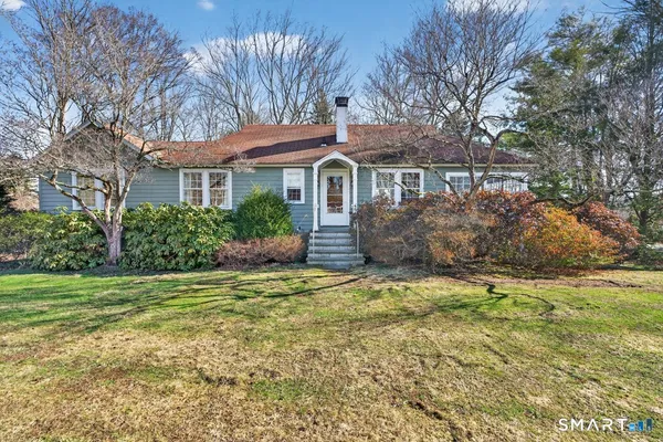 a kitchen with stainless steel appliances granite countertop a stove oven cabinets a dining table and chairs with wooden floor