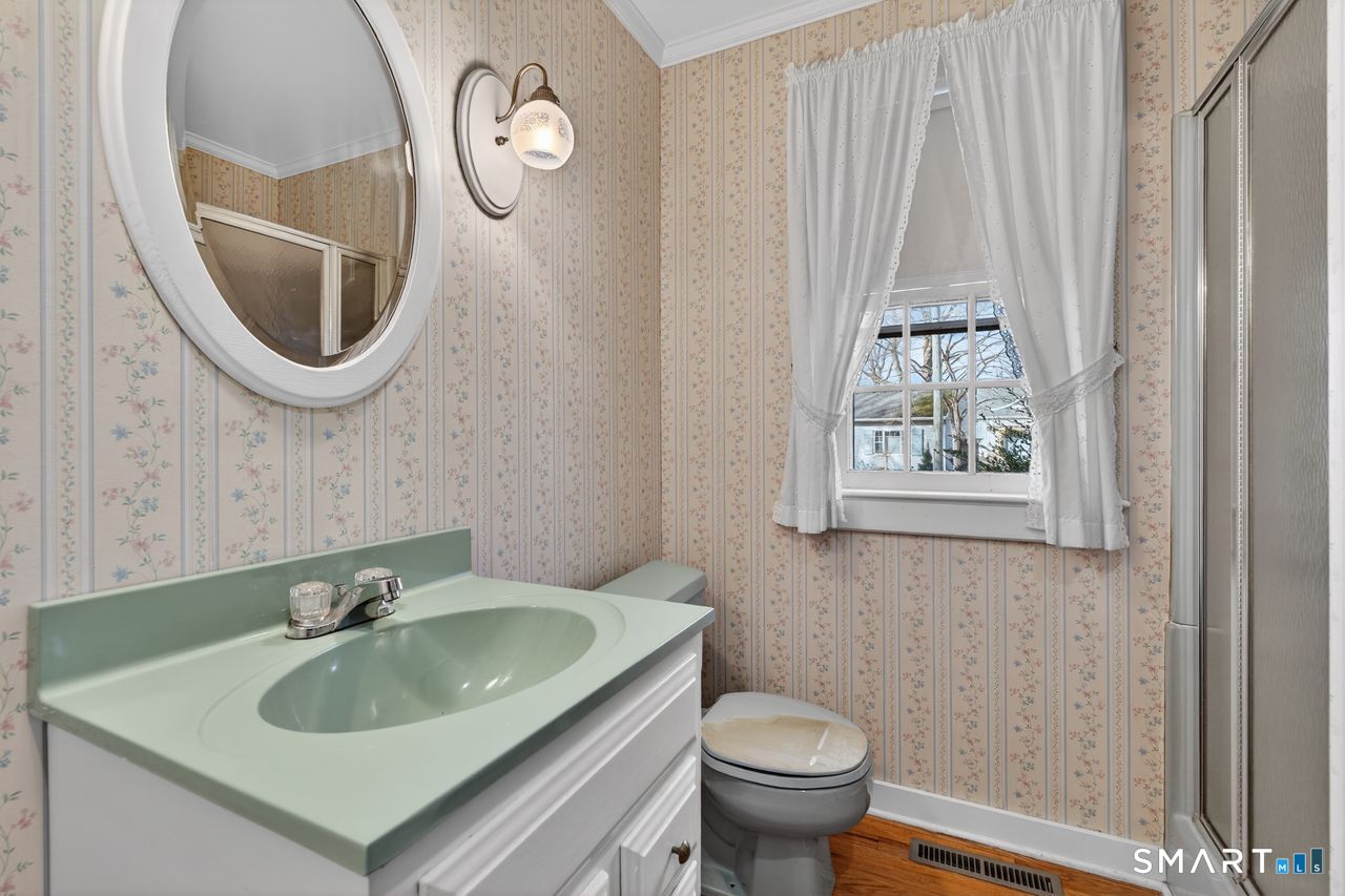 46 A Beach Avenue Madison, CT 06443 - Photo 32 of 32 a bathroom with a sink toilet and a mirror