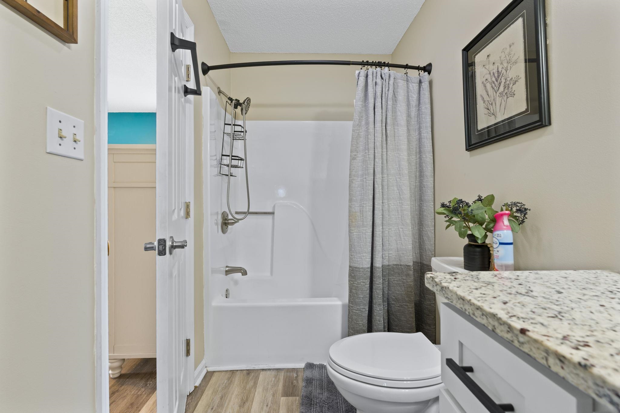 4353 Spa Drive, Unit 909 Little River, SC 29566 - Photo 21 of 39 Full bathroom with shower / bath combo with shower curtain, vanity, light wood-style flooring, and a textured ceiling