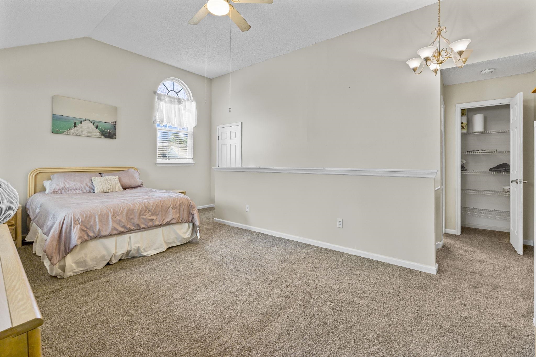 4353 Spa Drive, Unit 909 Little River, SC 29566 - Photo 28 of 39 Carpeted bedroom featuring a walk in closet, lofted ceiling, a chandelier, and a ceiling fan