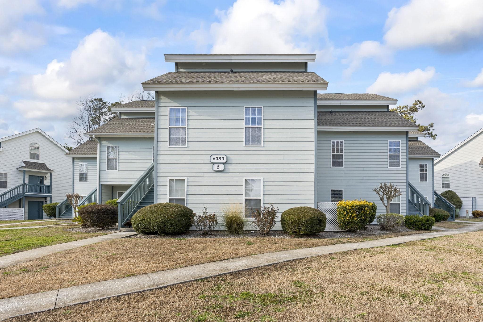4353 Spa Drive, Unit 909 Little River, SC 29566 - Photo 4 of 39 View of side of property with stairs, roof with shingles, and a lawn
