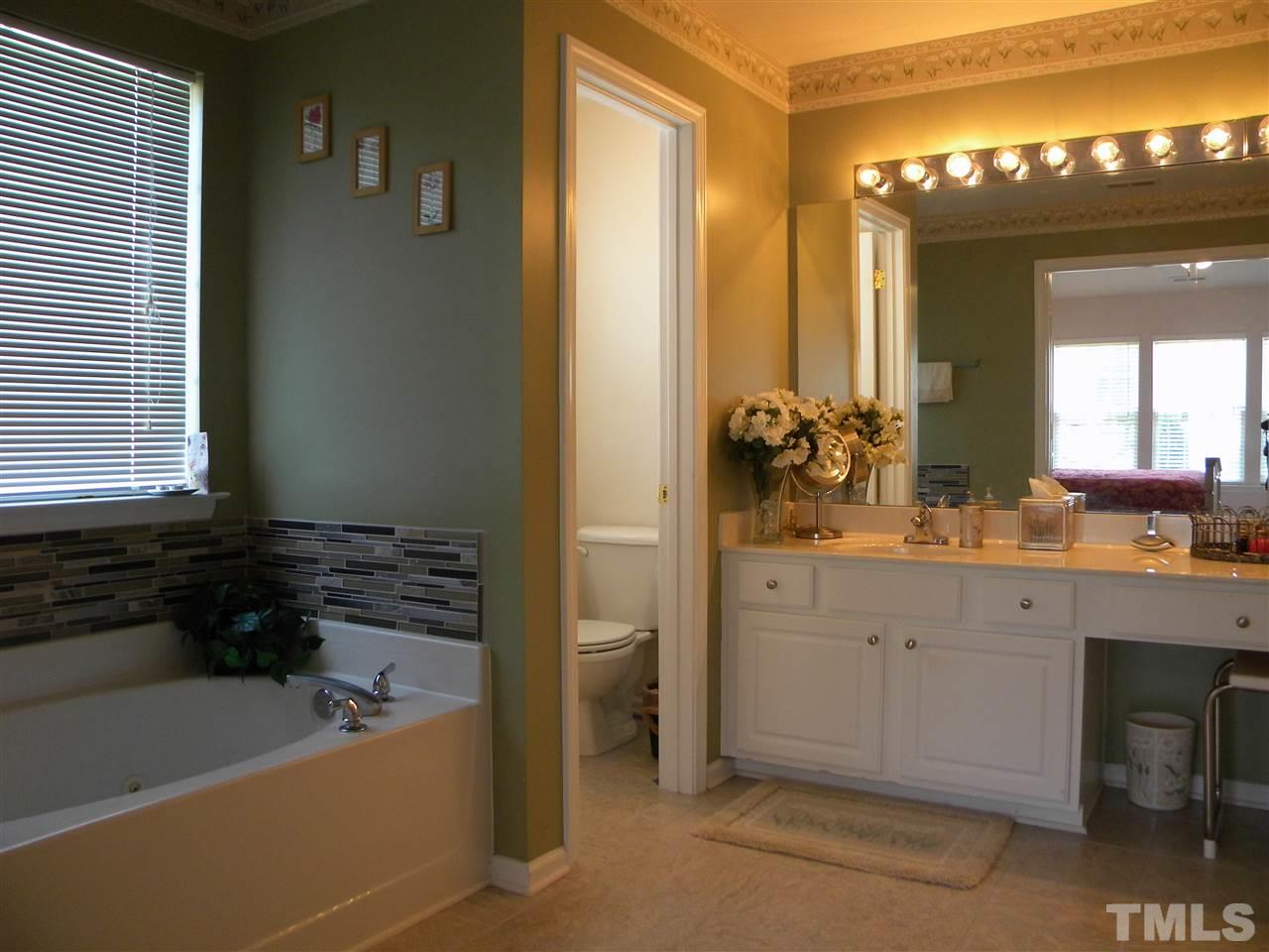 108 Rock River Road Morrisville, NC 27560 - Photo 16 of 25 a bathroom with a tub a double vanity sink and mirror