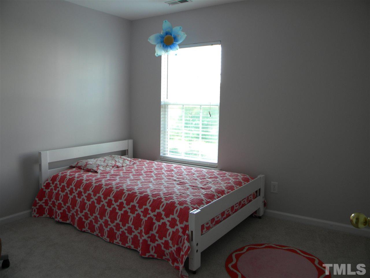 108 Rock River Road Morrisville, NC 27560 - Photo 17 of 25 a bed sitting in a bedroom next to a window