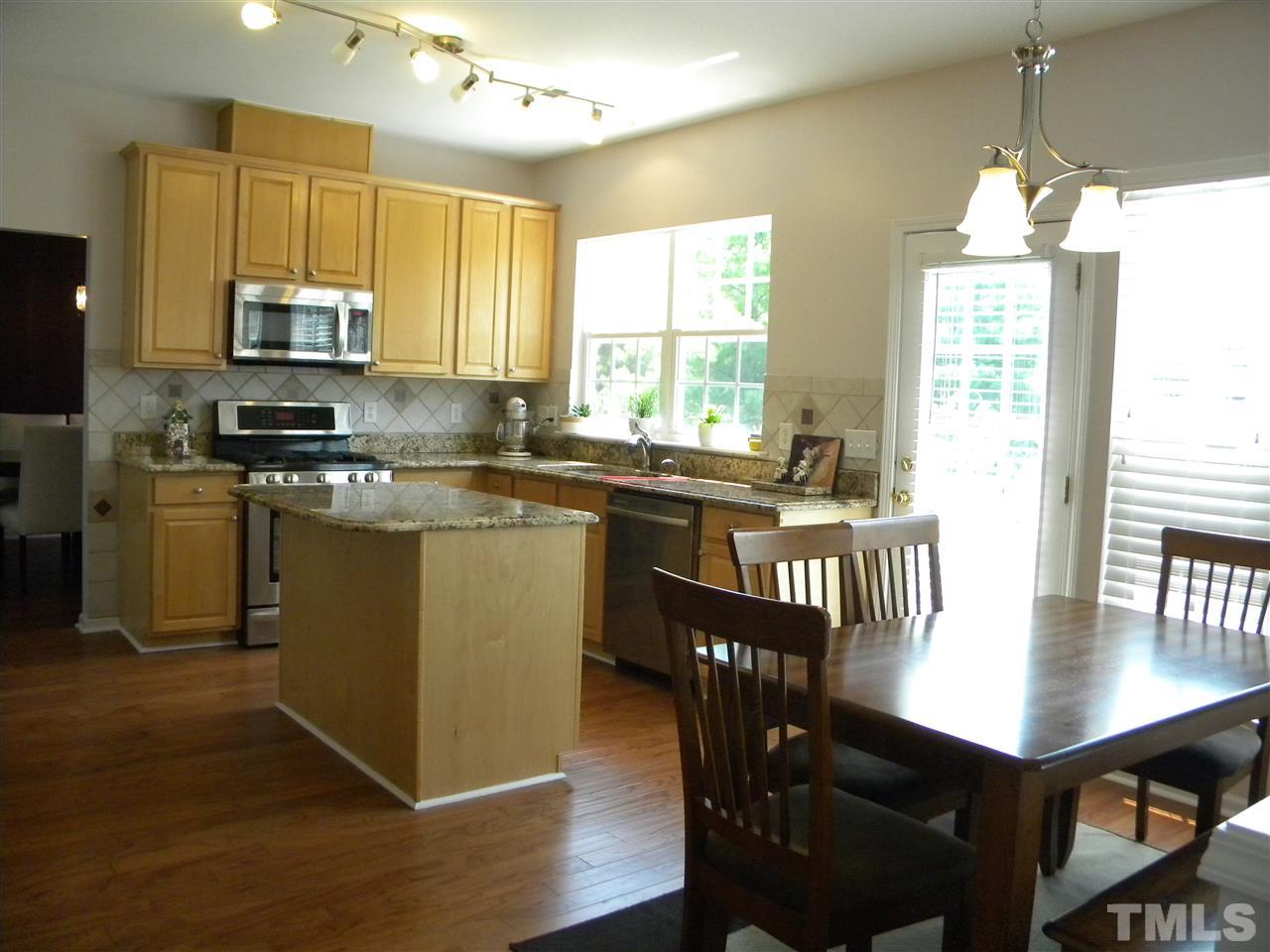 108 Rock River Road Morrisville, NC 27560 - Photo 5 of 25 a kitchen with stainless steel appliances granite countertop a stove a sink dishwasher a stove a refrigerator with a dining table and chairs