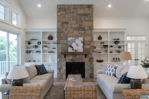 a kitchen with stainless steel appliances kitchen island granite countertop a refrigerator a sink dishwasher a dining table and chairs with wooden floor