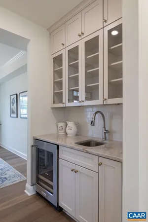 a bedroom with a bed a chair and potted plant on the dresser