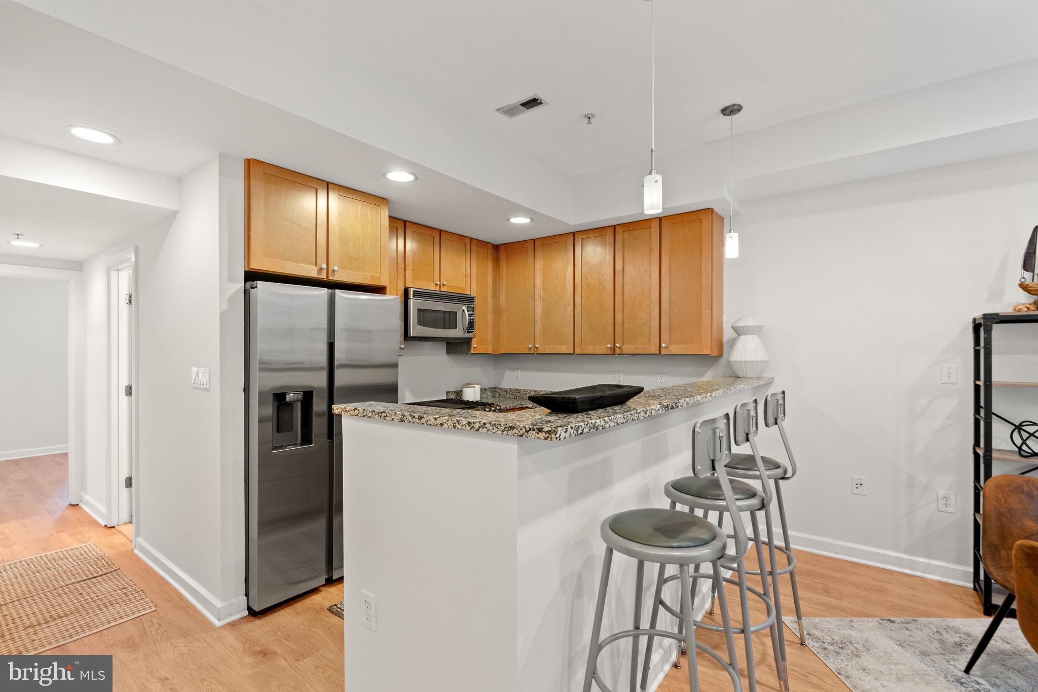 1421 Chapin Street Northwest, Unit 102 Washington, DC 20009 - Photo 12 of 37 a kitchen with stainless steel appliances granite countertop a stove a refrigerator and a refrigerator