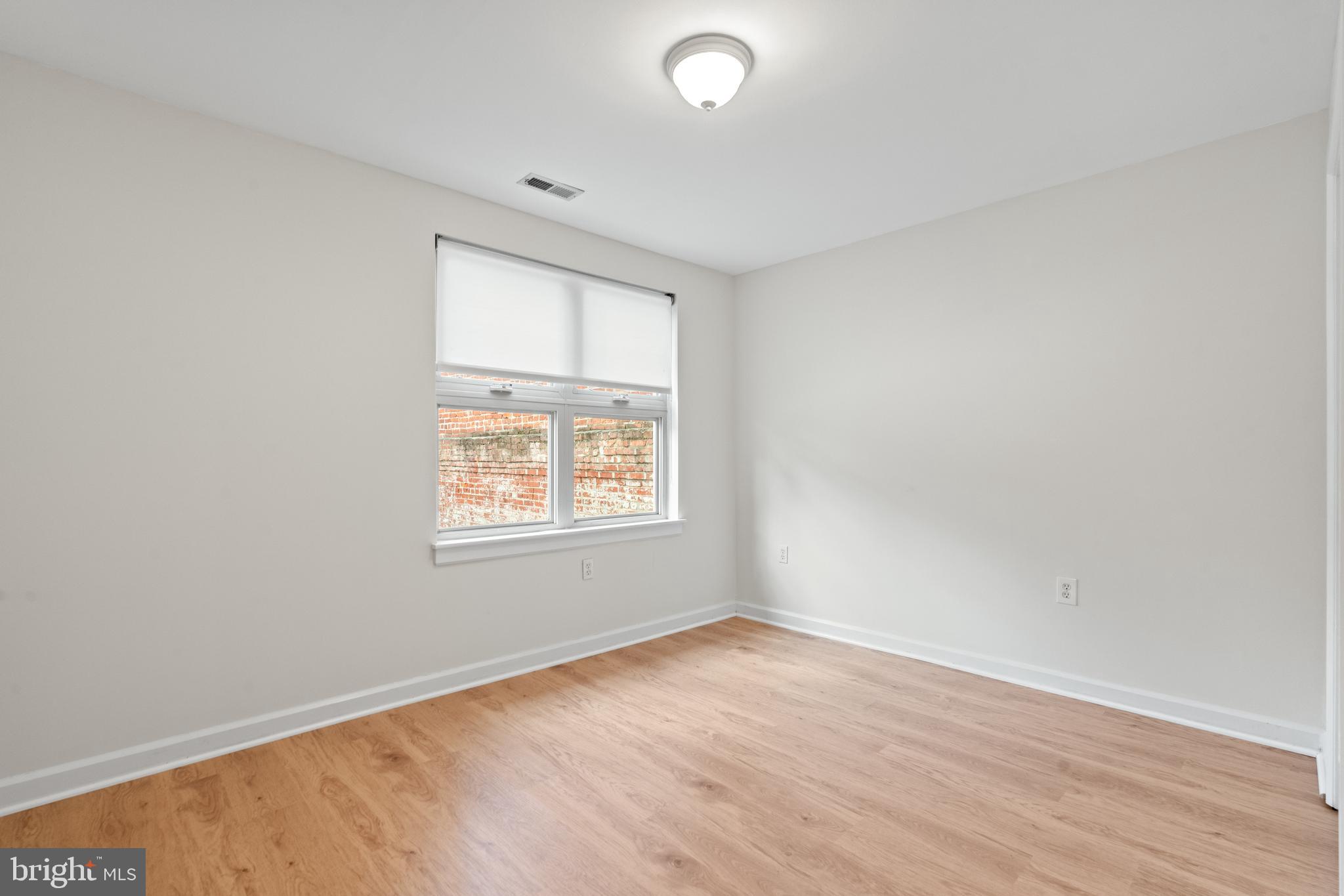 1421 Chapin Street Northwest, Unit 102 Washington, DC 20009 - Photo 15 of 37 an empty room with wooden floor and windows