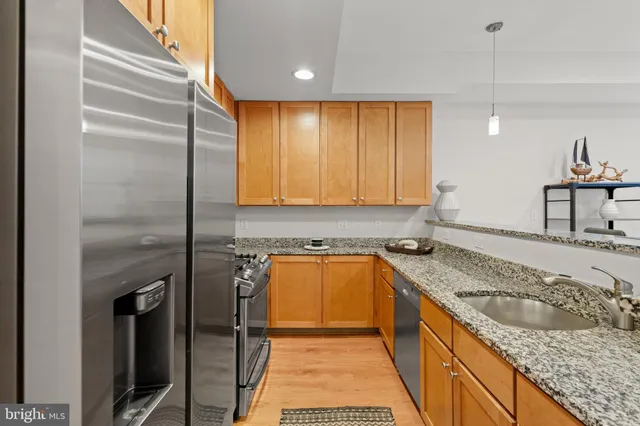 a kitchen with stainless steel appliances granite countertop a sink and a refrigerator