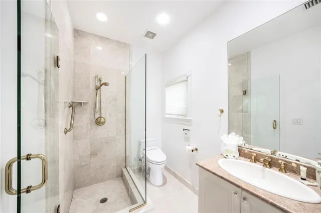 a bathroom with a double vanity sink toilet mirror and shower
