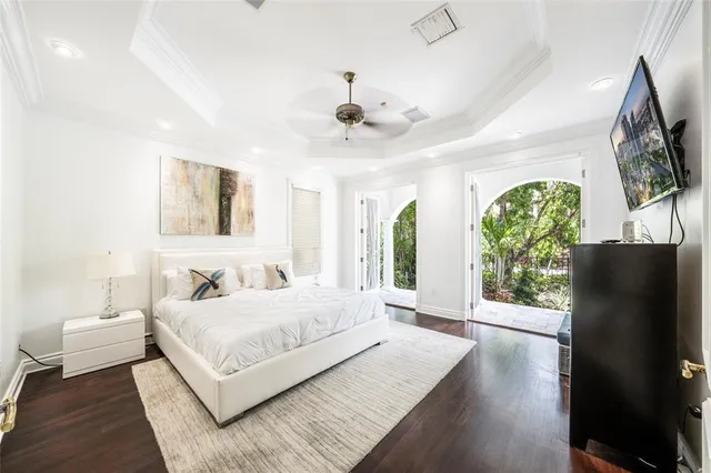 a bedroom with a large bed and a flat tv screen on dresser