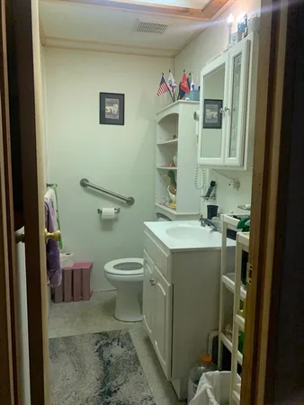 a bathroom with a toilet sink and mirror