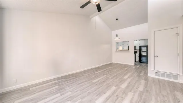 a view of empty room with wooden floor