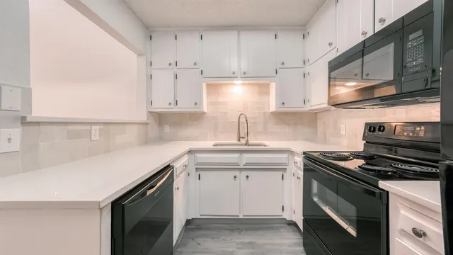a kitchen with stainless steel appliances granite countertop a sink stove and cabinets