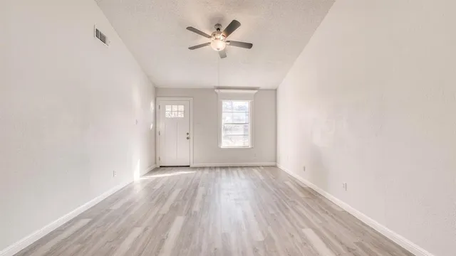 wooden floor in an empty room with a window