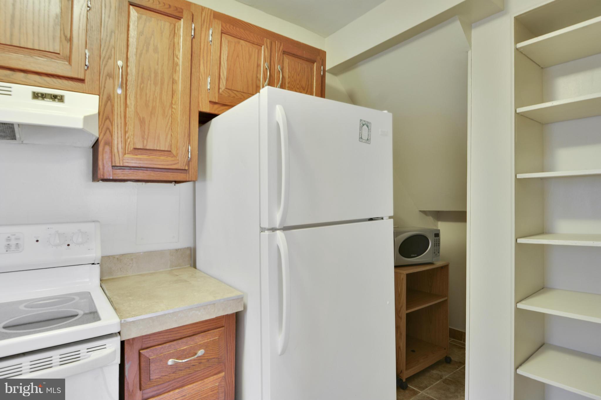 54 Ridge Road, Unit G Greenbelt, MD 20770 - Photo 6 of 30 a white refrigerator freezer and a stove sitting inside of a kitchen