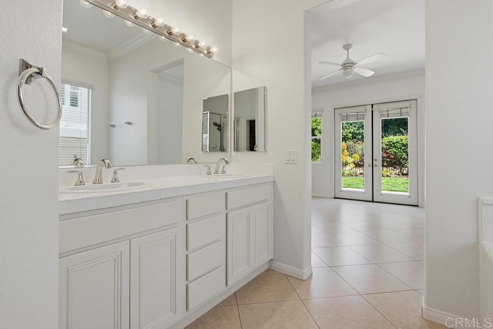 672 Inverlochy Drive Fallbrook, CA 92028 - Photo 37 of 75 a bathroom with a double vanity sink a mirror and a bathtub