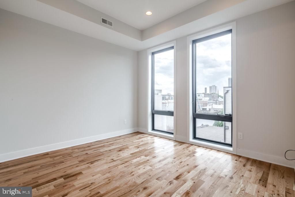 514 South Street, Unit 206 Philadelphia, PA 19147 - Photo 4 of 9 an empty room with wooden floor and windows