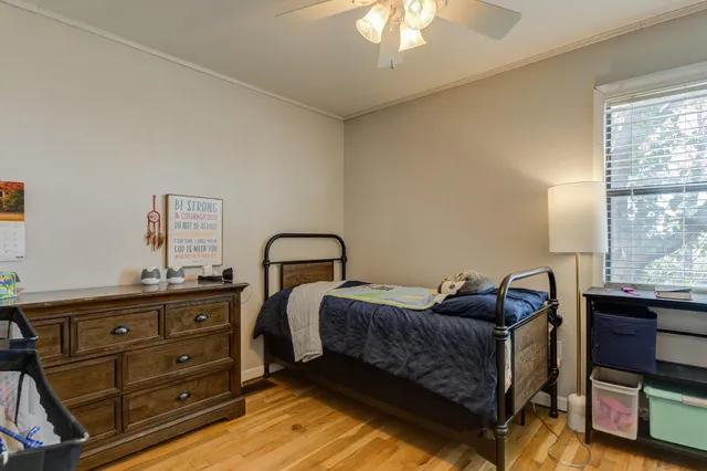 a bedroom with a bed and wooden floor