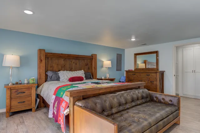 a bedroom with a bed and wooden floor